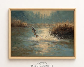 Puede incluir: Una pintura de paisaje enmarcada que representa un pez saltando de un río con agua salpicando, sobre un fondo de juncos dorados y árboles oscuros. El texto Wild Country Collective está impreso en negro debajo de la obra de arte enmarcada.