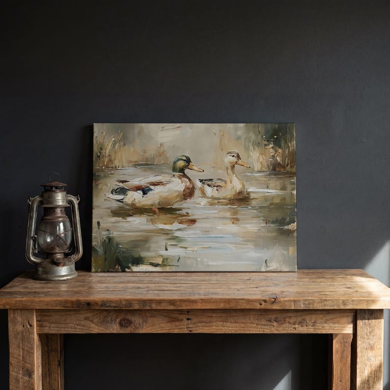 a painting of ducks swimming in a pond, displayed on a wooden table.