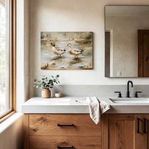 a bathroom with a large mirror, a wooden vanity, and a painting of ducks on the wall.