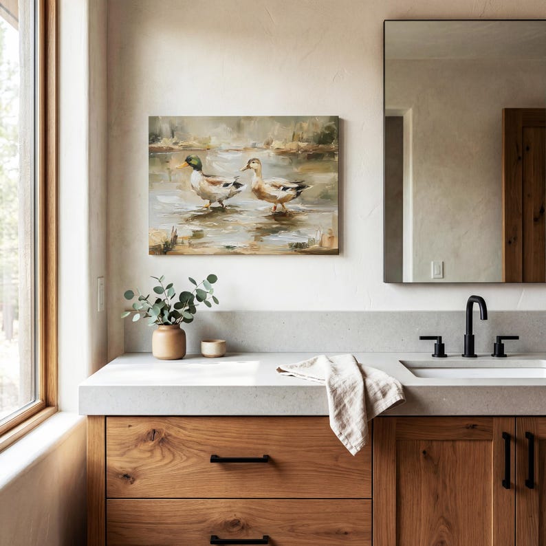 a bathroom with a large mirror, a wooden vanity, and a painting of ducks on the wall.
