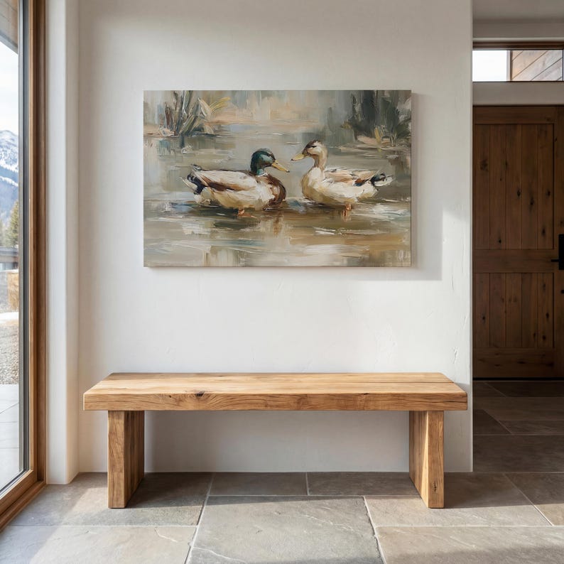 a wooden bench situated in a room with a large painting of ducks hanging on the wall above it.