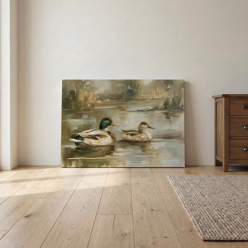 a painting of two ducks swimming in a pond, displayed on a wall in a room with a wooden floor.