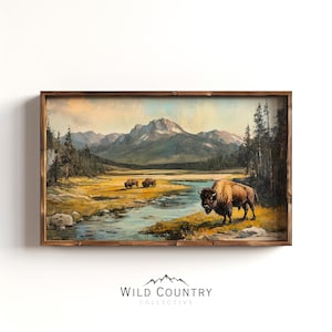 May include: A framed vintage painting of a mountain landscape with a river and a herd of bison. The painting is in a rustic wooden frame.