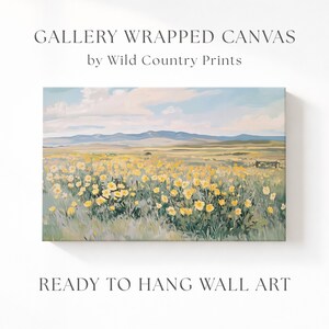 Puede incluir: Un lienzo envuelto en galería de Wild Country Prints con una pintura de paisaje de un campo de flores silvestres amarillas bajo un cielo nublado con montañas distantes. El texto dice GALLERY WRAPPED CANVAS by Wild Country Prints y READY TO HANG WALL ART.