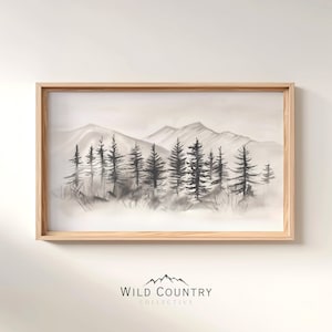 May include: A framed black and white watercolor painting of a mountain range with a forest of trees in the foreground. The painting has a minimalist style and is framed in a light wood frame.