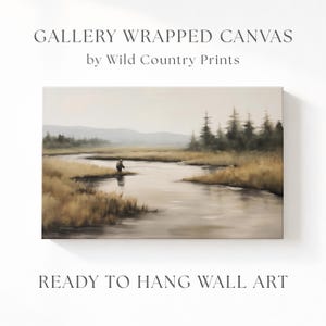 May include: Gallery wrapped canvas wall art featuring a serene landscape painting of a person fishing in a river. The artwork has a neutral color palette with text that reads "Gallery Wrapped Canvas by Wild Country Prints" and "Ready to Hang Wall Art."