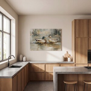 a modern kitchen with wooden cabinets, a large window, and a painting of ducks on the wall.