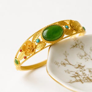 Armband i orientalisk vintagestil med guldfärgat tryck | Grönt cabochonarmband | Manschett i blommigt chinoiseriemönster | Uttalande