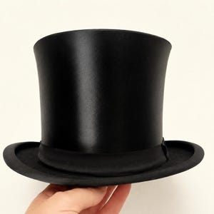 May include: A black top hat with a smooth, satin-like finish and a structured cylindrical crown. The hat features a wide, curved brim and a matching black fabric band encircling the base of the crown, creating a uniform and monochromatic appearance.