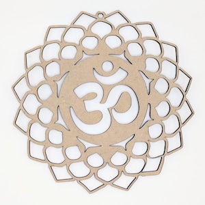 Puede incluir: Adorno de pared de madera cortado con láser con el símbolo Om en el centro. El diseño es un patrón de mandala con un acabado de madera natural. La forma circular tiene un pequeño agujero en la parte superior para colgar. El fondo es blanco.