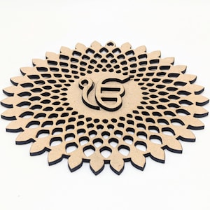 Puede incluir: Un posavasos de madera cortado con láser con un diseño floral y un símbolo central. El posavasos es de color marrón claro con bordes negros, y el símbolo también es de color marrón claro. El diseño es intrincado y detallado.