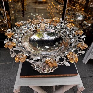 Large fruit display stand decorated with lotus flowers on feet.