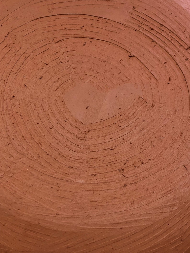 Detail of sienna ceramic vase during creation.