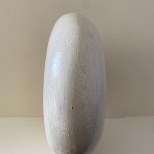 Side of an off white ceramic ambience lamp.