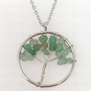 May include: A silver chain necklace with a circular pendant featuring a wire-wrapped tree of life design. The tree is made of green and light green gemstone chips.