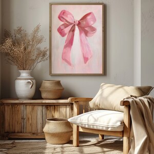May include: A painting of a large pink bow on a light pink background. The bow is tied with a single knot and the ends of the ribbon are flowing down.