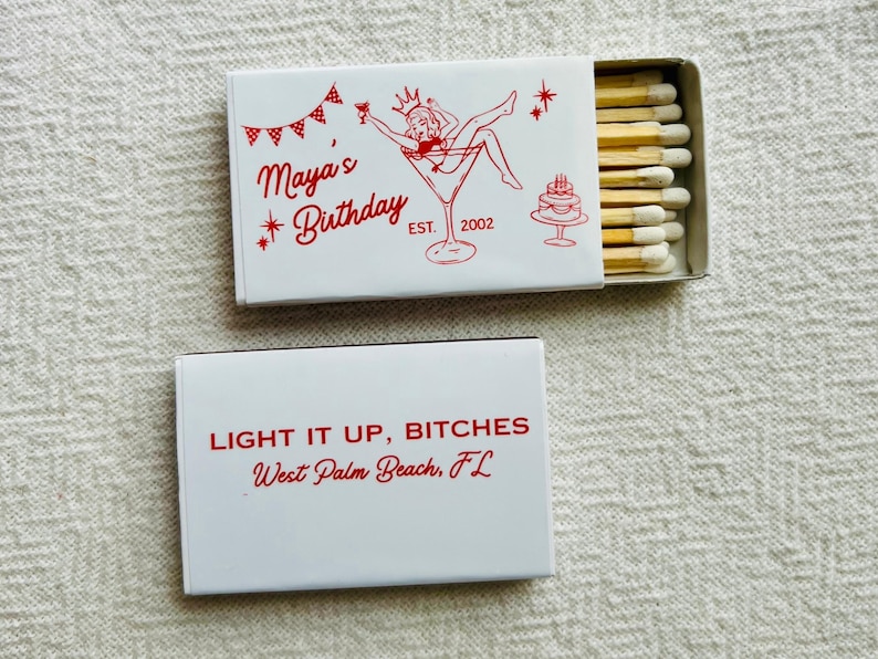 May include: Two white matchboxes with red text and illustrations. One box reads "Maya's Birthday" with a martini glass illustration. The other box reads "LIGHT IT UP, BITCHES" and "West Palm Beach, FL".