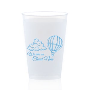 May include: White disposable cup with a blue graphic of a hot air balloon and a cloud. The text "We are on Cloud Nine" is printed below the graphic.