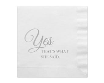 May include: White square napkin with the word "Yes" in a cursive font, followed by "THAT'S WHAT SHE SAID" in a sans-serif font. The napkin has a textured surface and a ribbed border.