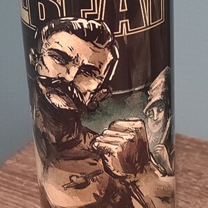 May include: A black and gold stainless steel tumbler with a graphic of a man with a mustache and the word "BEAT" in large letters. The text "AL & LET'S BOOGIE" is at the bottom of the tumbler.