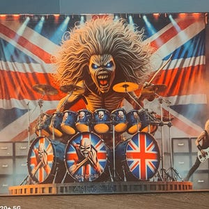 May include: A metal print of a rock band drummer with a Union Jack flag in the background. The drummer is wearing a skull mask and is playing a drum set. The text "Iron Maiden" is visible on the drum.
