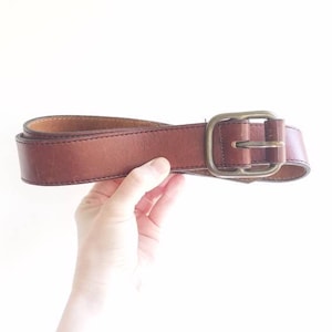 Classic cognac fine leather belt with brass hardware. Wide thick brown leather belt with stitched detailing. 1970&#39;s leather belt. Large 38&quot;.