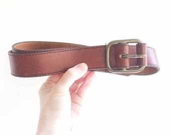 Classic cognac fine leather belt with brass hardware. Wide thick brown leather belt with stitched detailing. 1970's leather belt. Large 38".