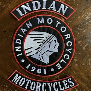 Könnte beinhalten: Zwei gestickte schwarze und weiße Patches mit rotem Rand. Der größere Patch ist rund und zeigt ein Indianerkopf-Logo mit dem Text "INDIAN MOTORCYCLE 1901". Der kleinere Patch ist ein gebogenes Banner mit dem Text "INDIAN MOTORCYCLES".
