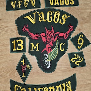 May include: A set of embroidered patches featuring a red devil with wings, the words "VAGOS" and "CALIFORNIA", and the numbers "13", "1%", "6", and "22".