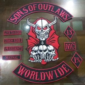 以下が含まれることがあります： 「Sons of Outlaws Worldwide」という文字と、角と赤い目をした頭蓋骨が刺繍された黒と赤のワッペン。ワッペンには、「Live to Ride」、「Demon Rider」、「President」、「Original」、「13」、「IMC」、「1%」という文字が書かれた小さなワッペンも含まれています。