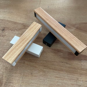 May include: Two wooden light fixtures with white diffusers. One fixture is laying on a wooden surface, while the other is standing upright with a black base.