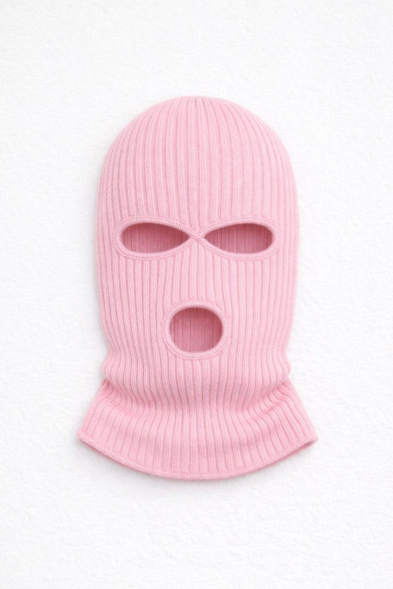 Puede incluir: Un pasamonta&ntilde;as de punto rosa claro con tres aberturas para ojos y boca. La prenda para la cabeza est&aacute; hecha de tejido de punto acanalado. El pasamonta&ntilde;as est&aacute; dise&ntilde;ado para cubrir la cabeza y el cuello.