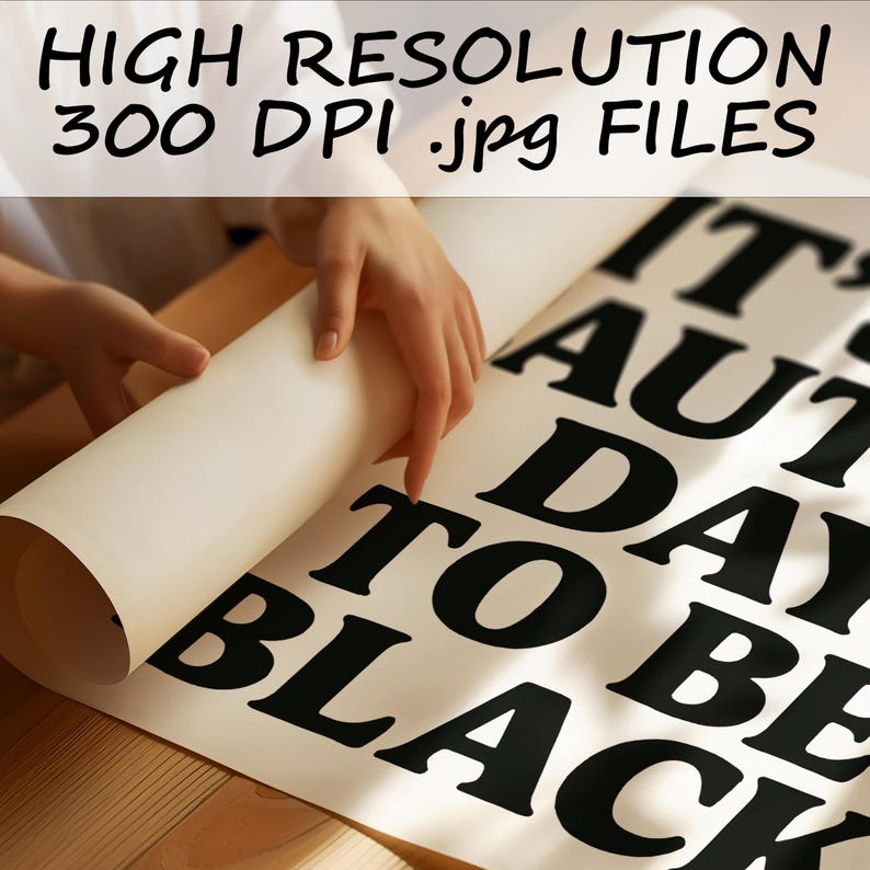 May include: A person is unrolling a large white poster with black text that reads "IT'S AUTUMN DAY TO BE BLACK." The top of the poster has the text "HIGH RESOLUTION 300 DPI .jpg FILES."