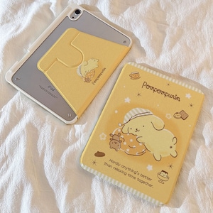 Puede incluir: Dos fundas para iPad con estampado amarillo y blanco. Una funda presenta un perro de dibujos animados con el texto "Pompompurin" y "Hardly anything's better than relaxing time together." La otra funda presenta un perro de dibujos animados con el texto "Pompompurin".