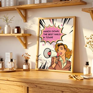 Professional nail salon shelf decor featuring a framed marketing poster. The "Best Nails in Town" sign is placed next to premium nail polish bottles, showing real-life usage. Assertive and fun branding for nail business owners.
