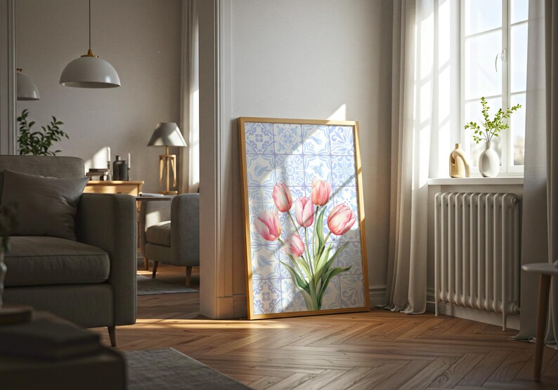 Digital wall art featuring a watercolor pink tulip bouquet on a blue and white Delftware tile background. This botanical poster is ideal for cottagecore, farmhouse, and Mediterranean-style kitchen or bathroom decor. With a background resembling Portuguese azulejo tiles and vibrant spring flowers, it offers a fresh and airy look. This printable image is perfect as a Mother's Day gift or seasonal spring decor.