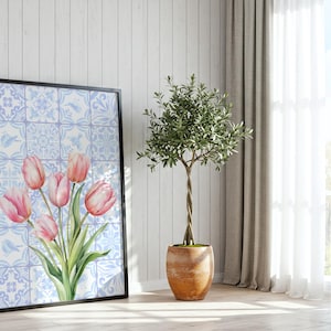 Digital wall art featuring a watercolor pink tulip bouquet on a blue and white Delftware tile background. This botanical poster is ideal for cottagecore, farmhouse, and Mediterranean-style kitchen or bathroom decor. With a background resembling Portuguese azulejo tiles and vibrant spring flowers, it offers a fresh and airy look. This printable image is perfect as a Mother's Day gift or seasonal spring decor.