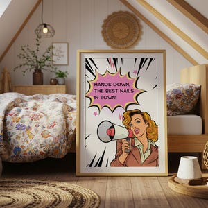 Retro style wall art featuring a woman with a megaphone displayed in a cozy room. "Hands Down" pun typography print for nail technicians. Fun and colorful comic book aesthetic poster for beauty room interior design.