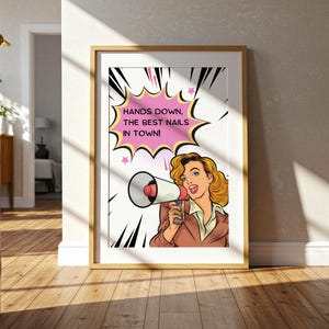 Bright hallway decor with a framed pop art poster leaning on the floor. Natural sunlight highlights the vibrant pink and yellow colors. Welcoming entrance sign for a trendy nail studio or spa to showcase confidence.
