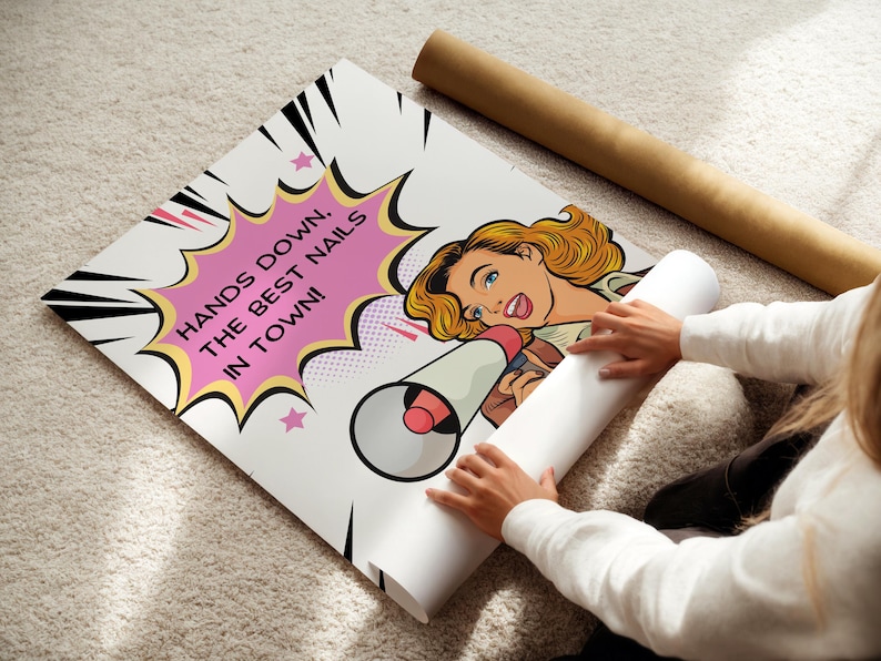 High-quality paper poster being unrolled on a carpet to show the full design. Comic book explosion background with a bold marketing slogan for nail artists. Durable wall art print for high-traffic salon areas.