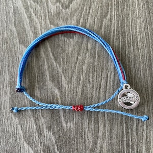 May include: A blue and red braided bracelet with a silver charm that says "DIABETIC".
