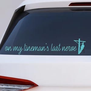 May include: A teal vinyl decal applied to a car window. The decal features the phrase "on my lineman's last nerve" in a cursive font, along with a silhouette of a lineman on a utility pole.