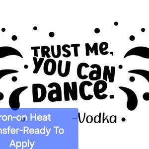 May include: Black and white iron-on heat transfer design with the text "TRUST ME, YOU CAN DANCE." and a decorative border of black dots and swirls. The text "Iron-on Heat Transfer-Ready To Apply -Vodka." is printed below the design.