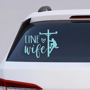 May include: A teal vinyl decal applied to a car window. The decal features the words "LINE wife" in a script font, with a heart symbol. A silhouette of a lineman on a utility pole is also included.