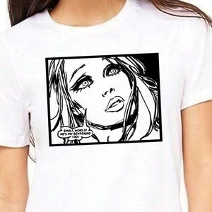 May include: White t-shirt featuring a black and white pop art graphic of a woman's face with the text "SMALL WORLD! HE'S MY BOYFRIEND TOO!" in a speech bubble. The graphic is framed in a black rectangle.