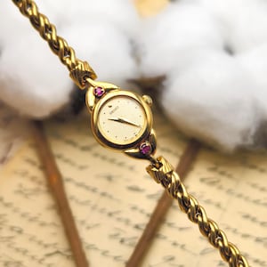 Reloj Seiko vintage de los años 90 para mujer, de cuarzo, tono dorado, esfera redonda y brazalete de cadena con detalles de rubí.