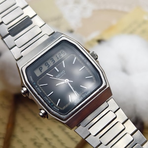 May include: A silver-tone Seiko Quartz SilverWave analogue-digital wristwatch featuring a rectangular case, a black dial with silver hour markers, and a metallic link bracelet. The digital display shows P 9:3 125, and the watch includes side buttons.