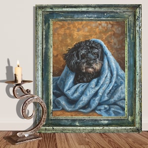 May include: A black poodle dog wrapped in a blue and gold patterned blanket, painted in a realistic style, framed in a dark green wood frame.
