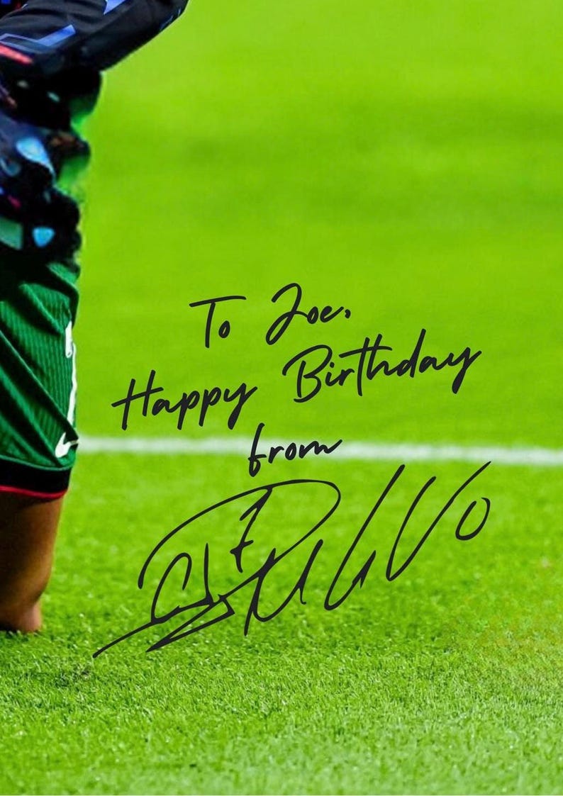 May include: A green soccer field with a white line. A soccer player is kneeling on the field. The player has written "To Joe. Happy Birthday from [signature]" on the field.