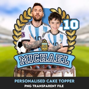 May include: A personalized cake topper featuring two figures in Argentina soccer jerseys, a soccer ball, and the name "MICHAEL" in a banner. The number "10" is displayed above the figures. The cake topper is decorated with a chocolate frosting and berries.